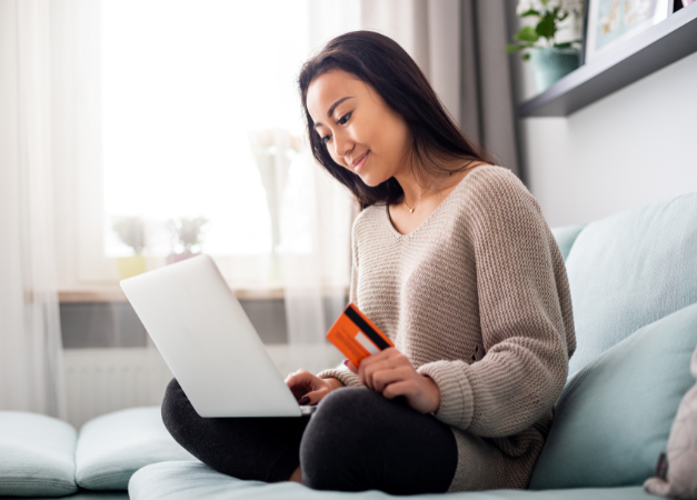 Woman holding a laptop and a credit card